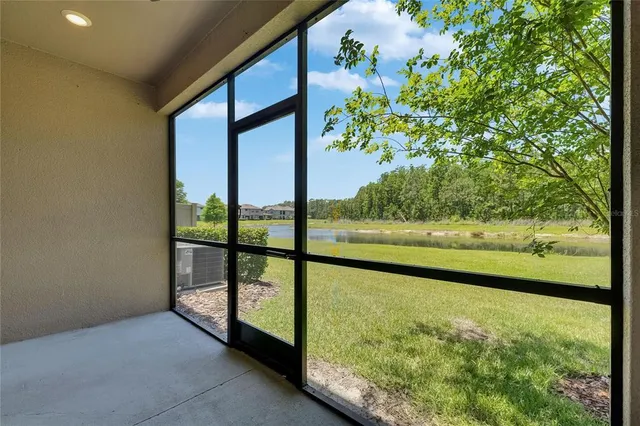 an aerial view of a house with outdoor space and trees all around