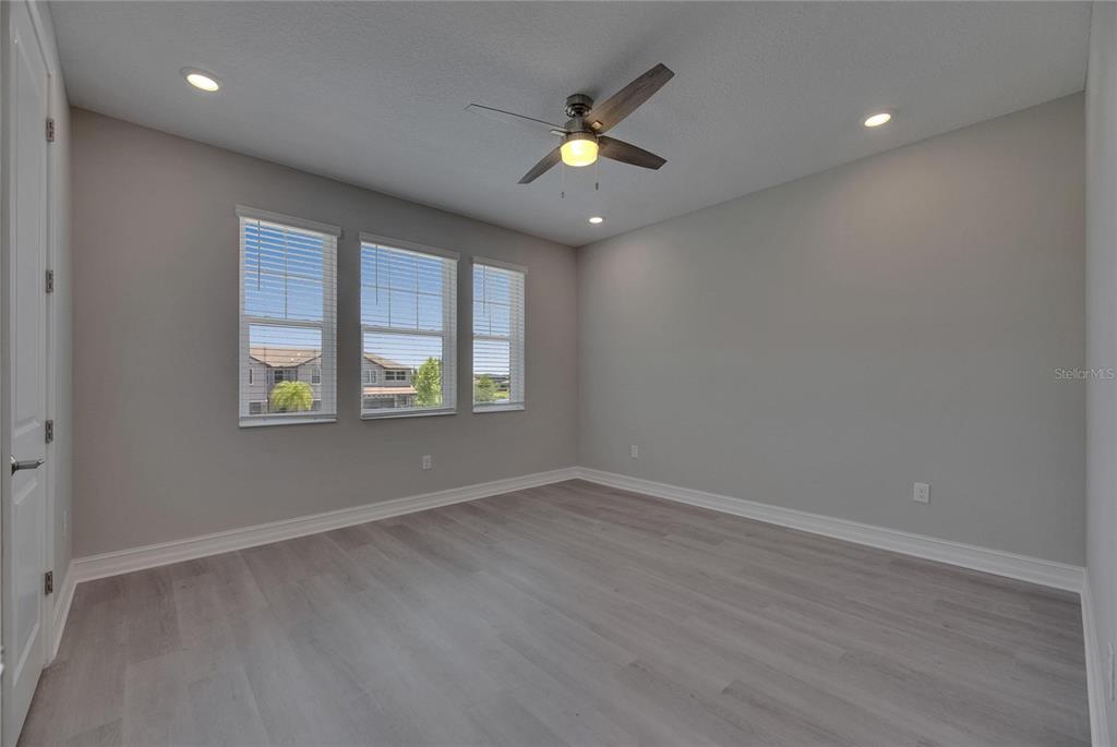4899 Isola Court Wesley Chapel, FL 33543 - Photo 50 of 86 an empty room with wooden floor and windows