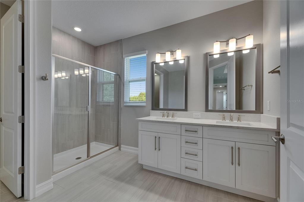 4899 Isola Court Wesley Chapel, FL 33543 - Photo 66 of 86 a bathroom with a double vanity sink and mirror