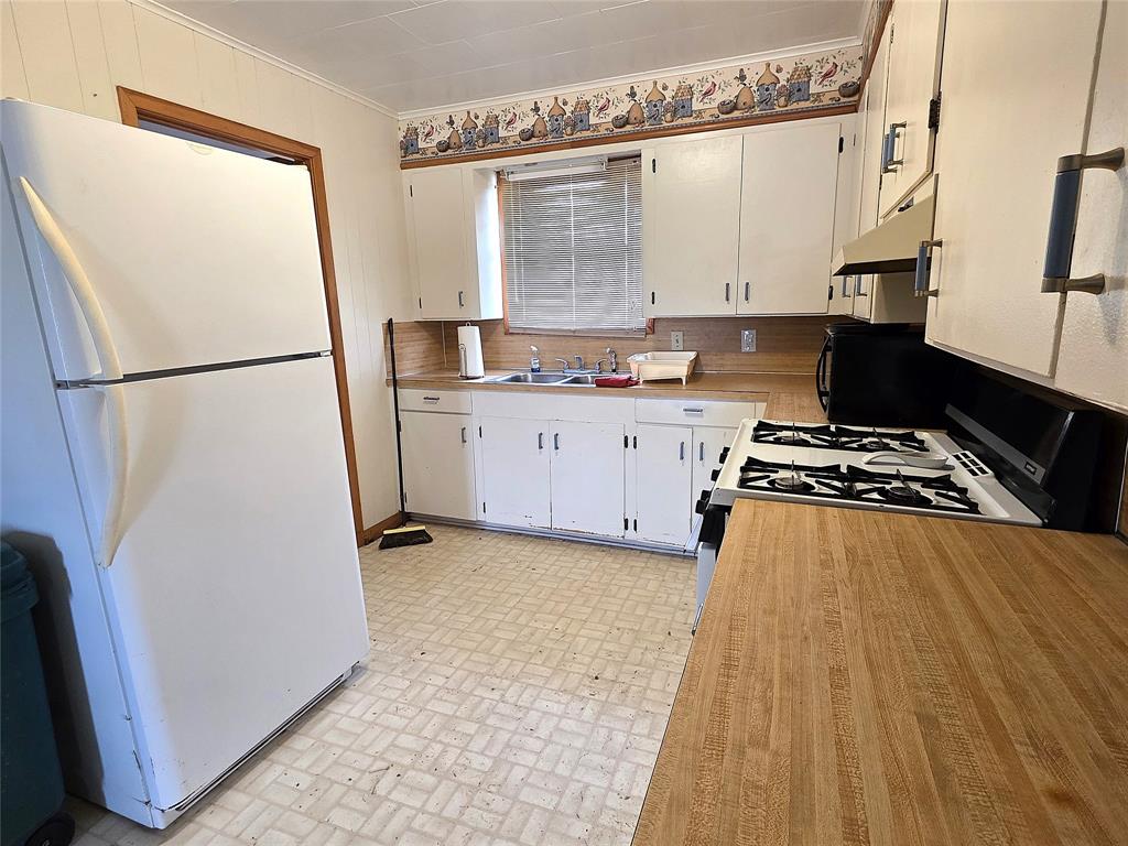 3049 Highway 507 Coushatta, LA 71019 - Photo 13 of 39 a kitchen with a refrigerator a stove a sink and white cabinets