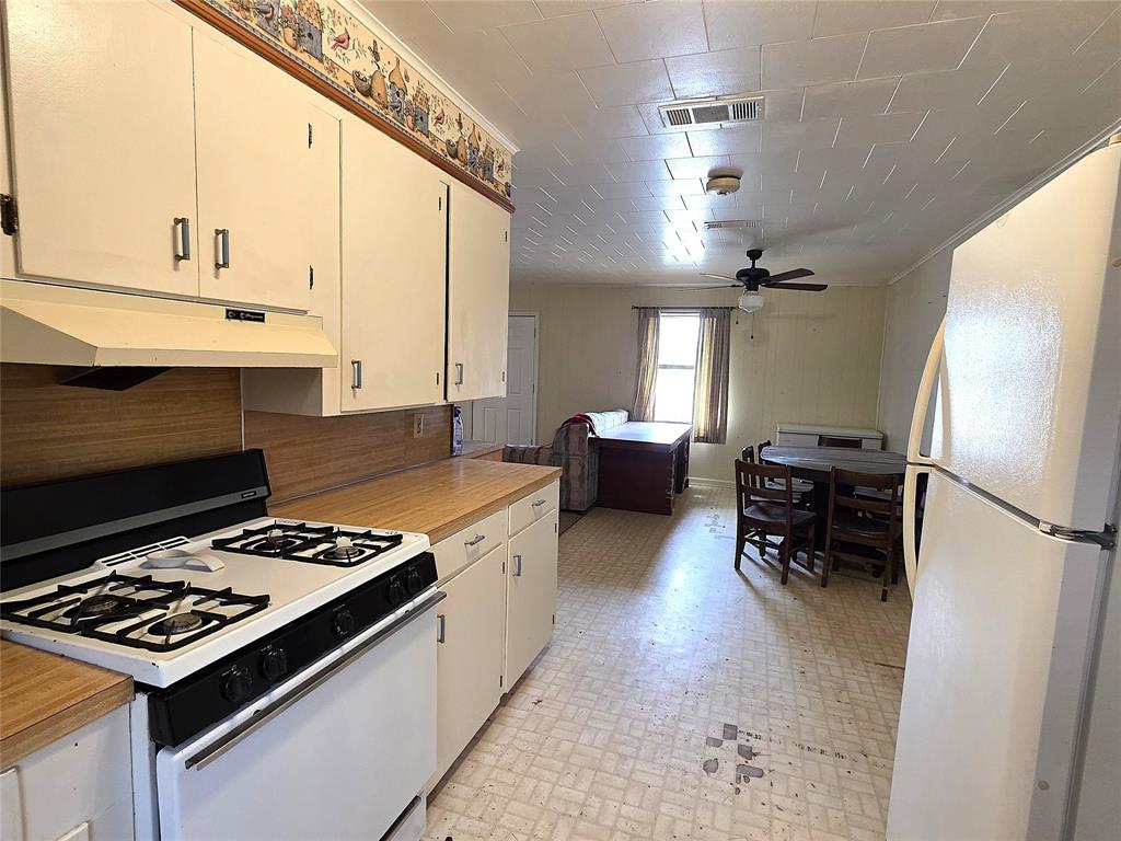 3049 Highway 507 Coushatta, LA 71019 - Photo 14 of 39 a kitchen with kitchen island white cabinets a sink a stove and a refrigerator