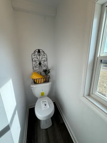 a bathroom with a toilet a sink and a window
