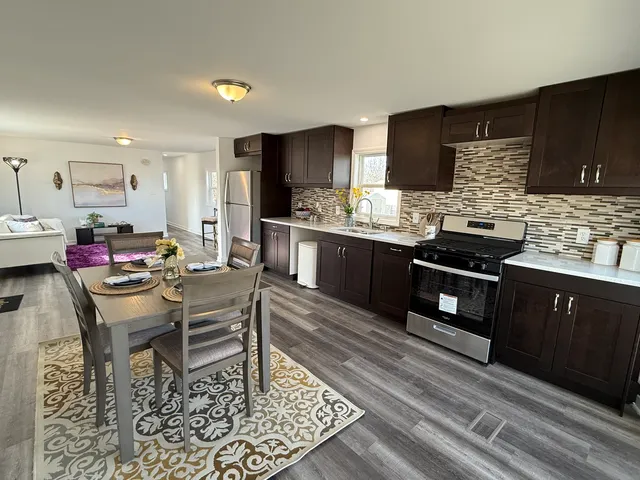 a kitchen with stainless steel appliances kitchen island granite countertop a sink and cabinets