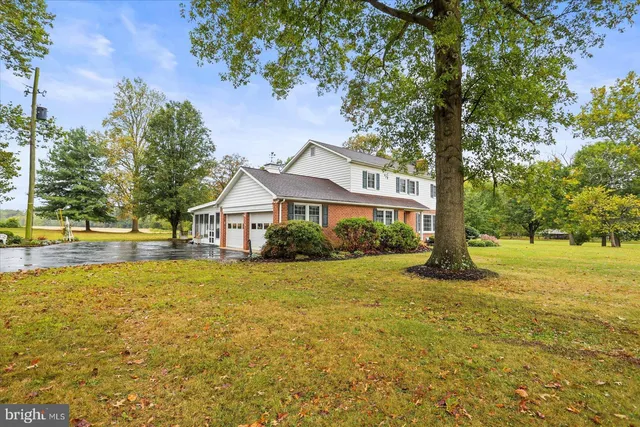 a front view of a house with yard and tree