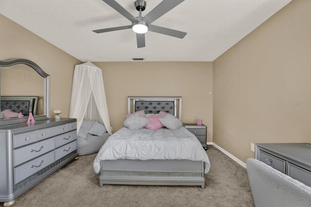 7487 River Country Drive Weeki Wachee, FL 34607 - Photo 33 of 53 a bedroom with a bed and a chandelier