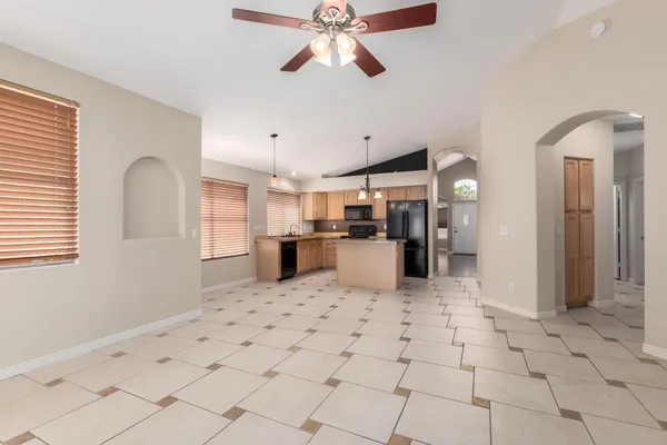 a kitchen with stainless steel appliances kitchen island granite countertop a refrigerator a stove a sink dishwasher and a refrigerator