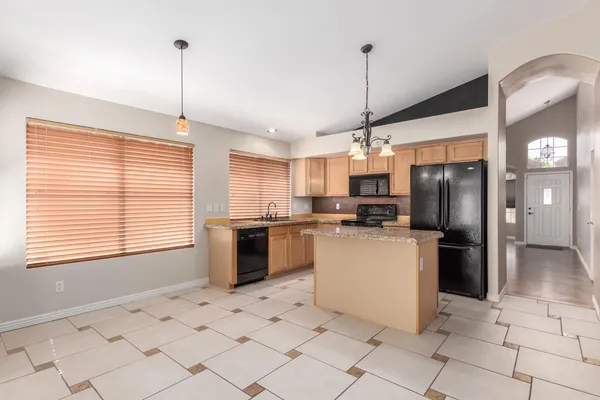 a kitchen with a sink stainless steel appliances and chandelier