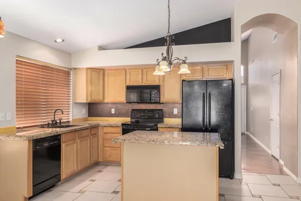 a kitchen with granite countertop cabinets stainless steel appliances and a window