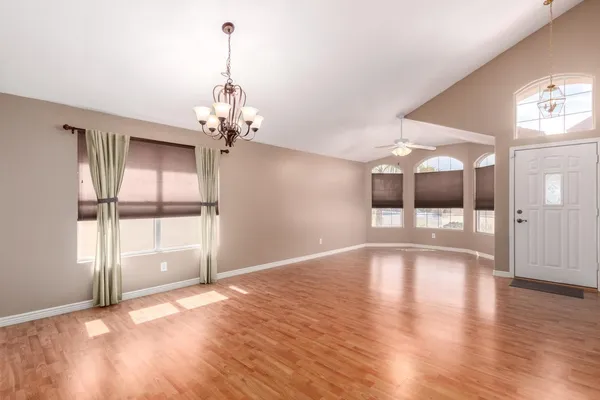 a view of an empty room with a window and wooden floor
