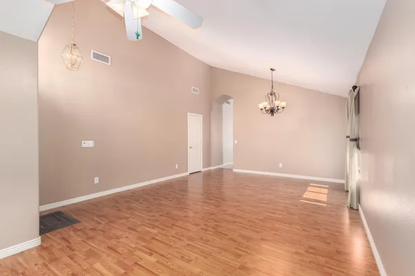 an empty room with wooden floor and a bathroom
