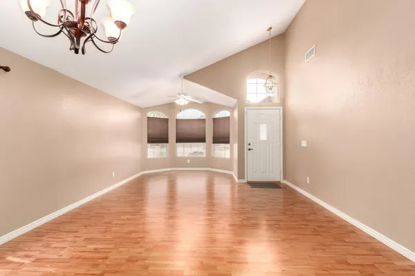 an empty room with windows and fireplace
