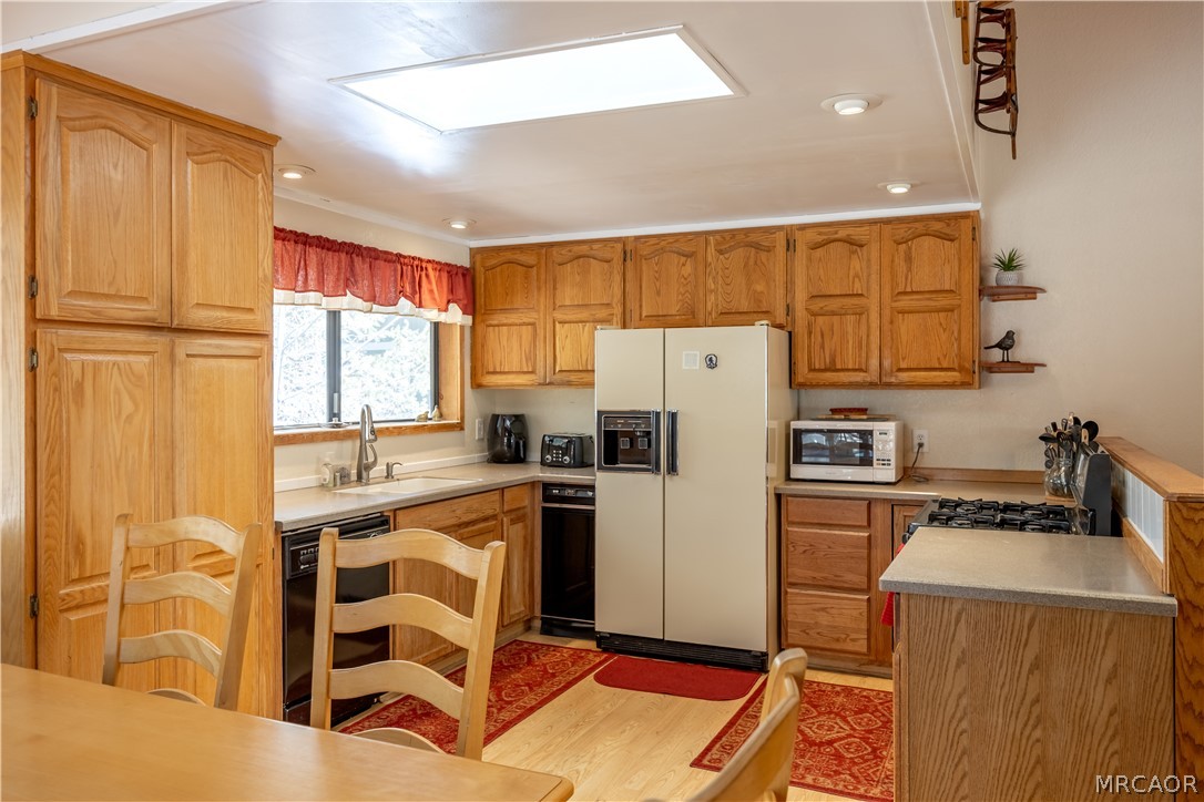 42324 Paramount Road Big Bear Lake, CA 92315 - Photo 11 of 50 a kitchen with refrigerator a stove a sink dishwasher and wooden cabinets with wooden floor