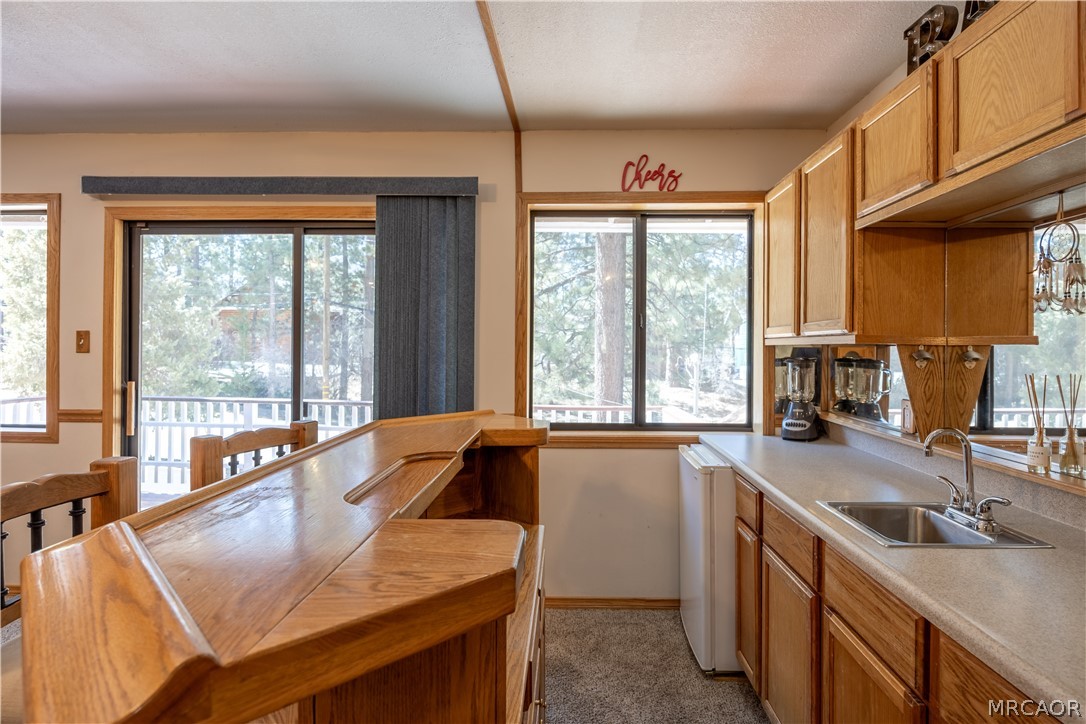 42324 Paramount Road Big Bear Lake, CA 92315 - Photo 27 of 50 a kitchen with a sink a counter top space and living room area