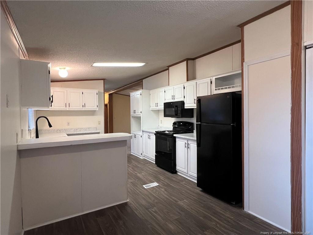 175 Travis Drive Cameron, NC 28326 - Photo 18 of 25 a kitchen with a refrigerator a sink and cabinets