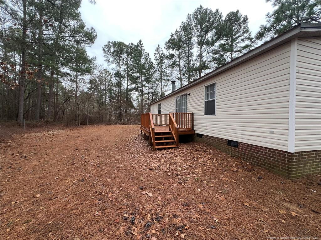 175 Travis Drive Cameron, NC 28326 - Photo 23 of 25 a backyard of a house with wooden fence and trees