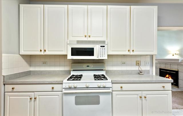 254 Charlotte Court Cary, IL 60013 - Photo 18 of 30 a kitchen with granite countertop white cabinets and white appliances