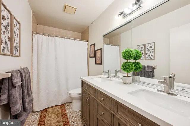 a bathroom with a sink a toilet and a mirror