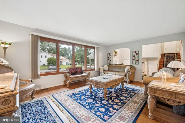 a living room with furniture a rug a lamp and a table