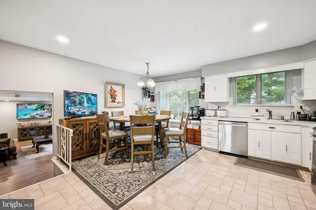 a kitchen with a refrigerator a stove a sink dishwasher with a dining table and chairs