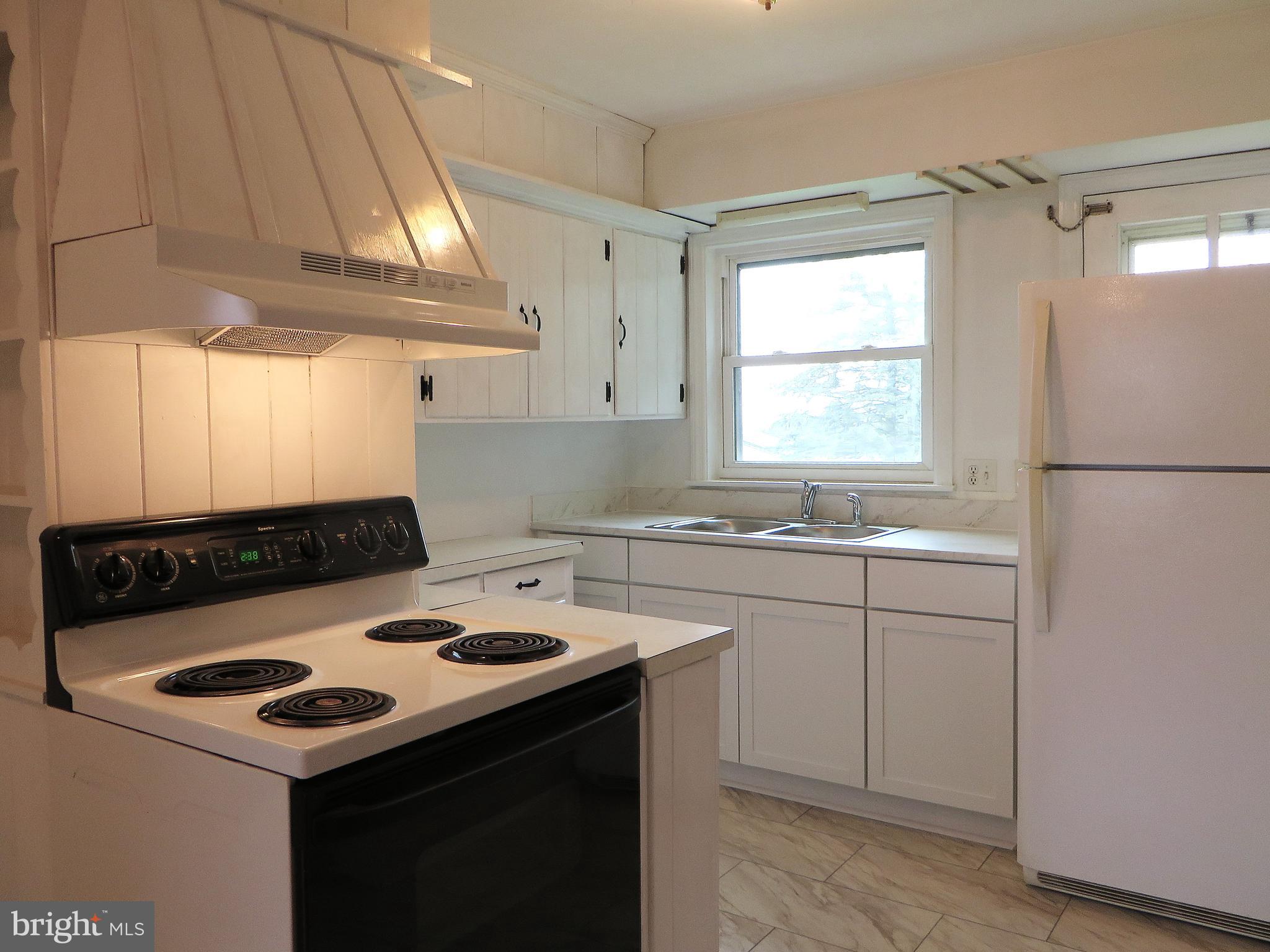 109 Chestnut Street Lititz, PA 17543 - Photo 7 of 15 a kitchen with a sink a stove cabinets and a window