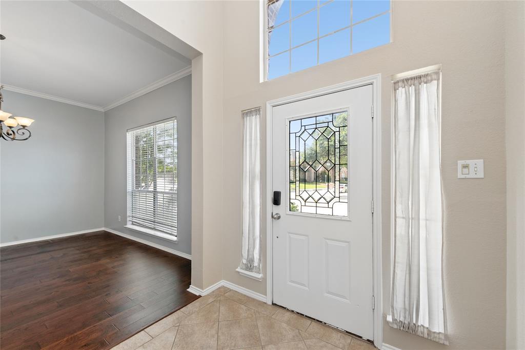 4202 Timberglen Road Dallas, TX 75287 - Photo 3 of 40 Two-story foyer featuring an ornate glass-paneled entry door, transom window, and tile flooring