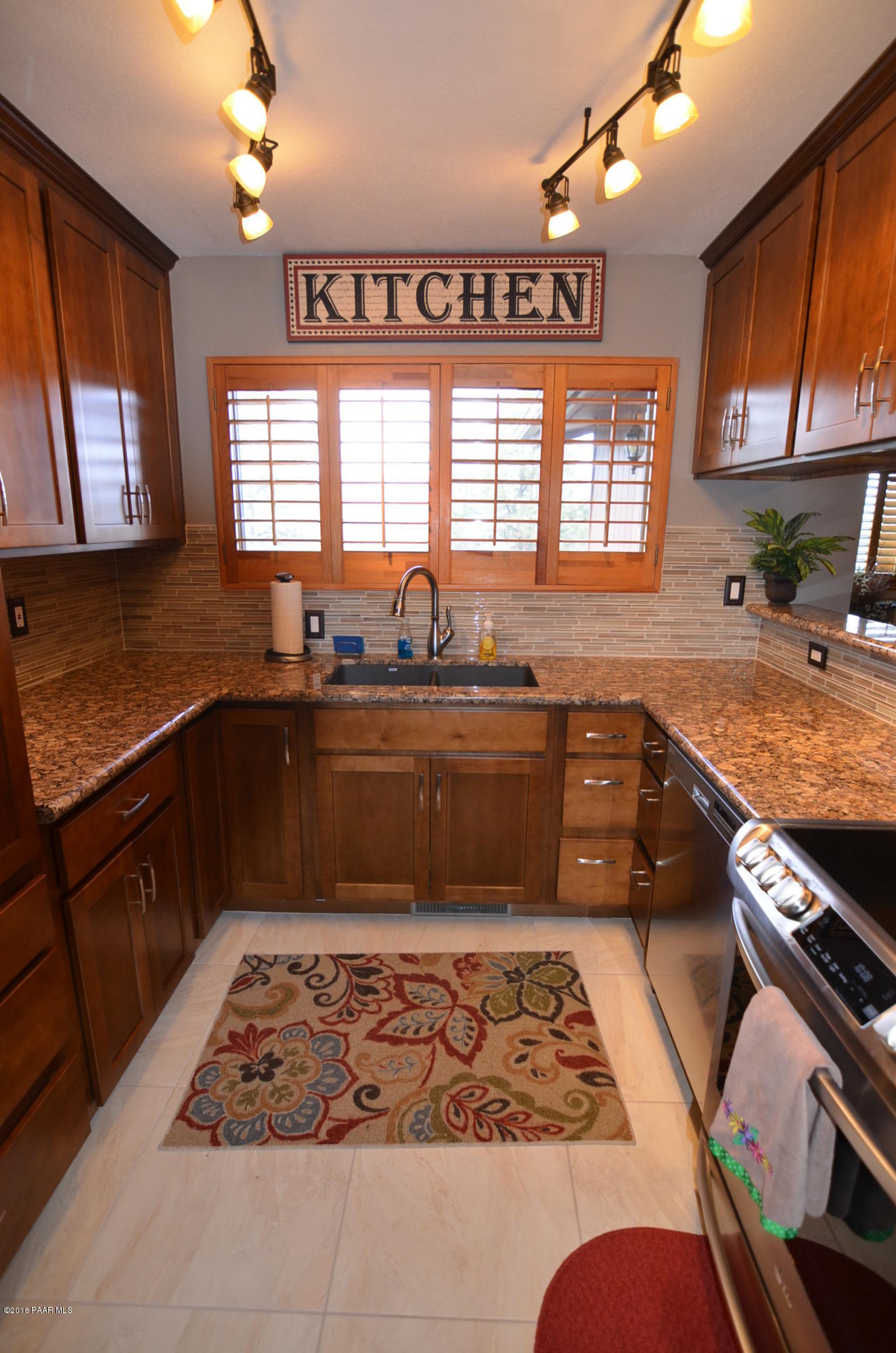1251 Tanglewood Road Prescott, AZ 86303 - Photo 11 of 39 a kitchen with stainless steel appliances granite countertop a sink stove granite counter tops and a window