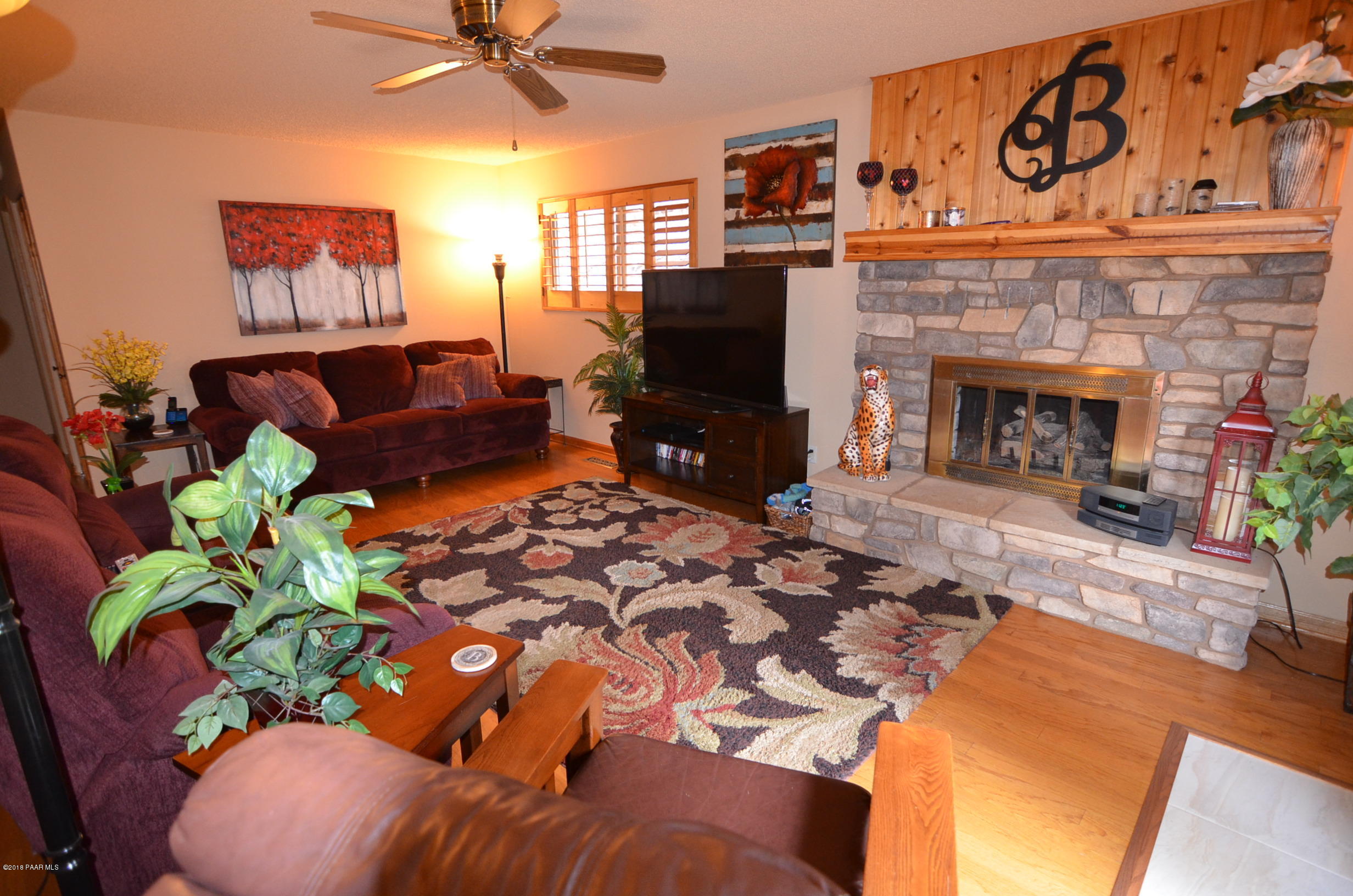 1251 Tanglewood Road Prescott, AZ 86303 - Photo 15 of 39 a living room with furniture a fireplace and a flat screen tv