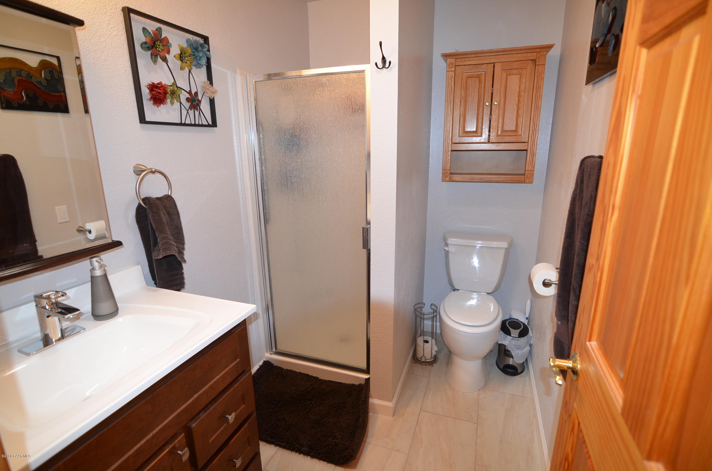 1251 Tanglewood Road Prescott, AZ 86303 - Photo 29 of 39 a bathroom with a sink a toilet and shower curtain