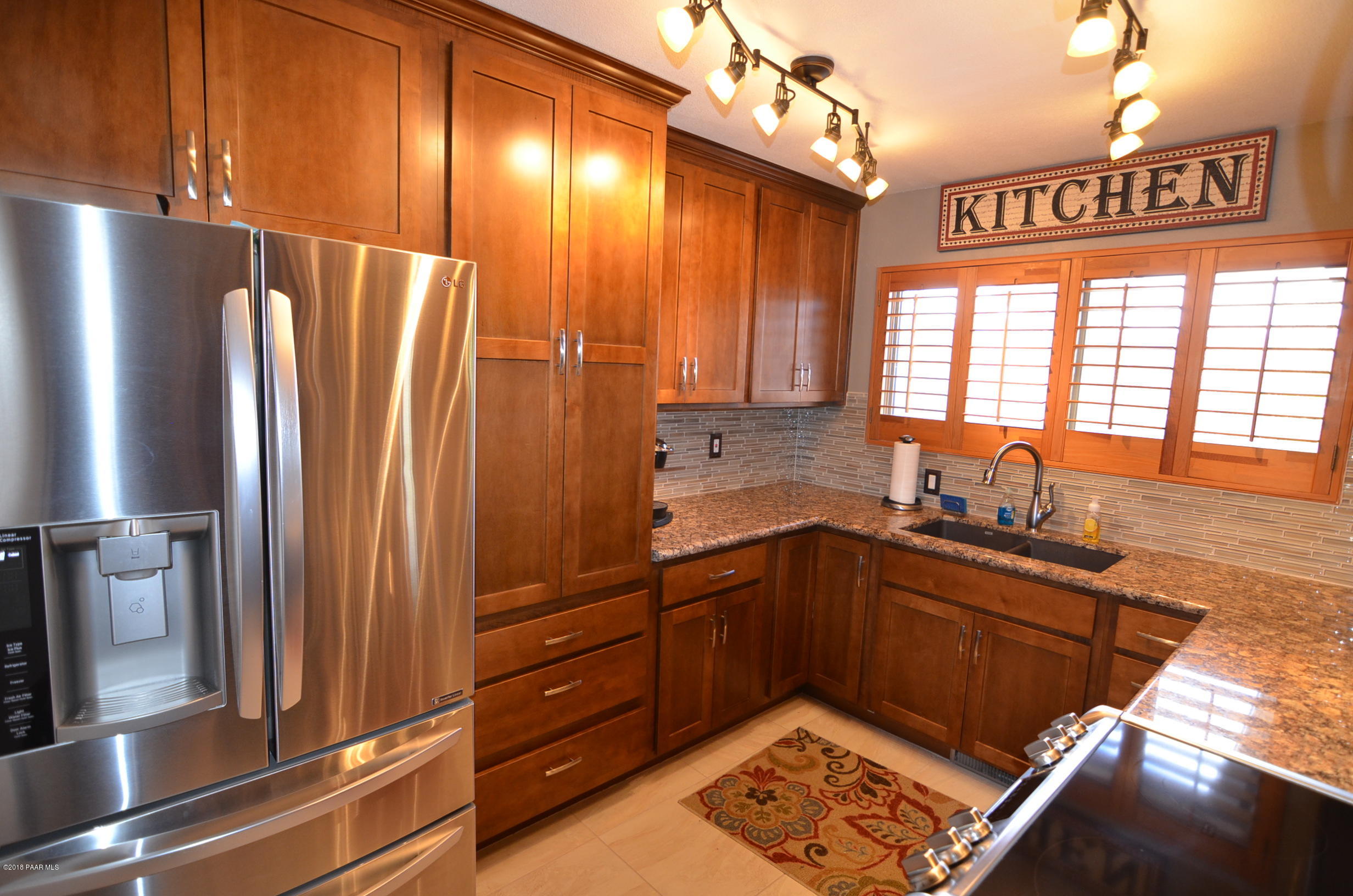 1251 Tanglewood Road Prescott, AZ 86303 - Photo 9 of 39 a kitchen with stainless steel appliances granite countertop a refrigerator and a sink