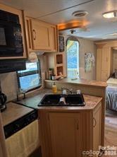 148 Trivette Trail Mount Gilead, NC 27306 - Photo 4 of 9 a kitchen with stainless steel appliances granite countertop a stove a sink and a microwave