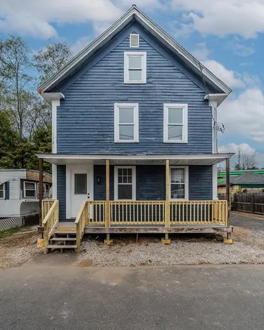 a view of a house with a yard and wooden fence