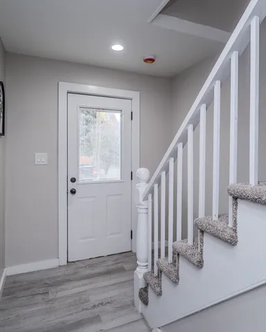 a view of a hallway with wooden floor and staircase