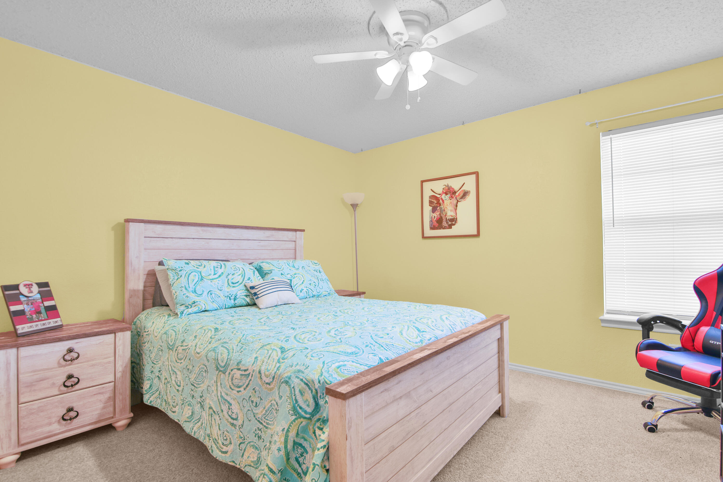 4805 73rd Street Lubbock, TX 79424 - Photo 17 of 26 a bedroom with a bed and a chandelier