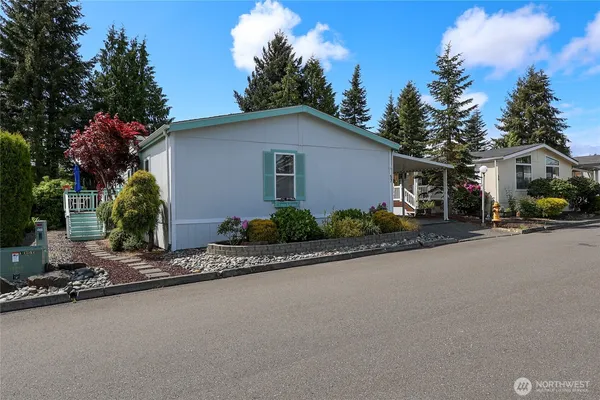 a front view of house with yard and trees in the background