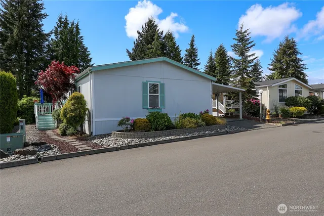 a front view of house with yard and trees in the background