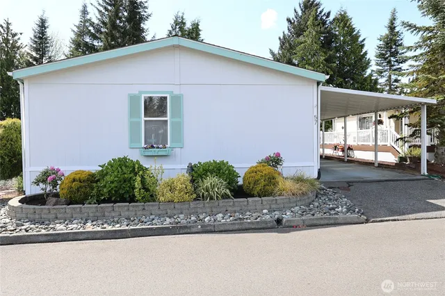 a front view of a house with a yard and potted plants