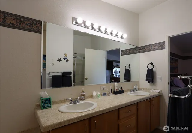a bathroom with a double vanity sink and a mirror