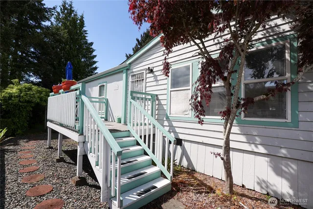 a view of wooden house with a small yard