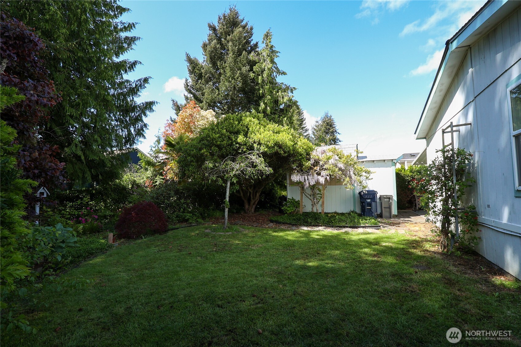 1427 100th Street Southwest, Unit 57 Everett, WA 98204 - Photo 29 of 38 a view of a backyard with table and chairs and potted plants and large tree