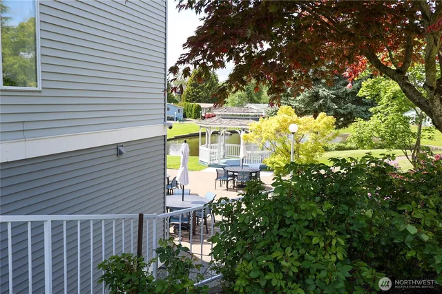 a balcony with table and chairs and a yard