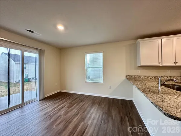 a view of a kitchen with wooden floor and a sink