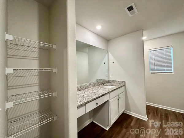a bathroom with a granite countertop sink a toilet and shower