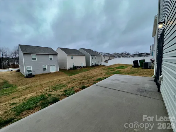 a view of a house with backyard and trees in the background