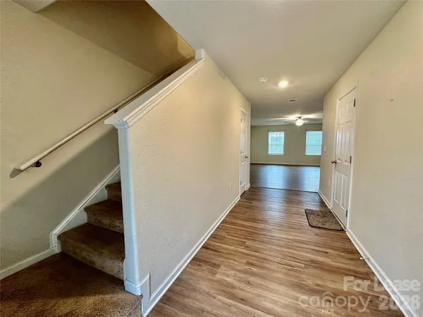 a view of a hallway with wooden floor and staircase