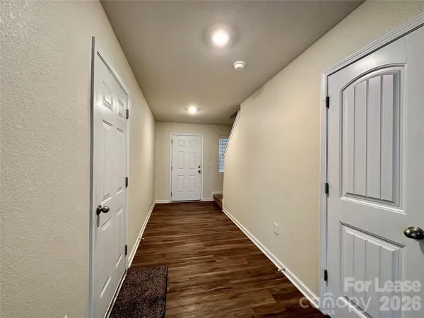 a view of a hallway with wooden floor and staircase