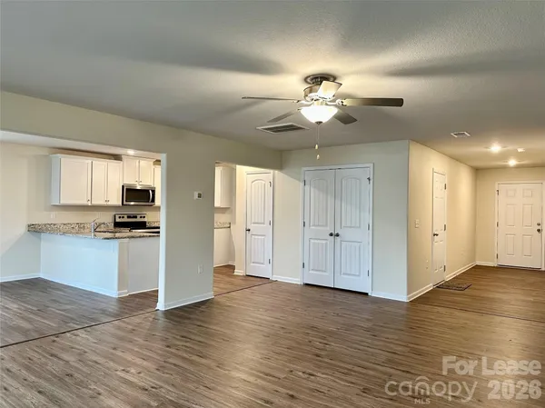 a view of a kitchen with an empty space wooden floor and a kitchen