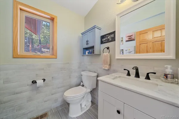 a bathroom with a toilet a sink and mirror