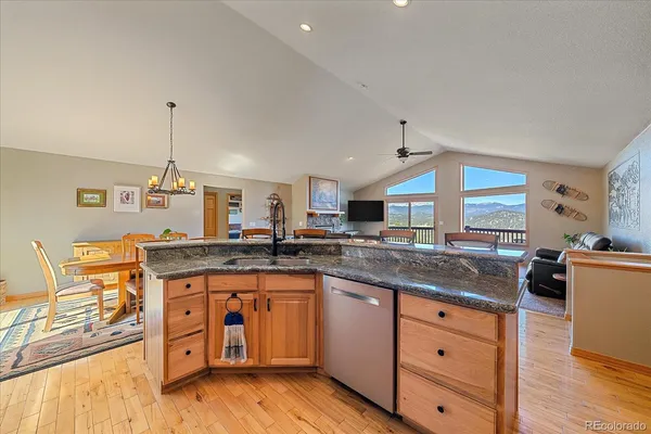 a kitchen with granite countertop a sink cabinets and wooden floor