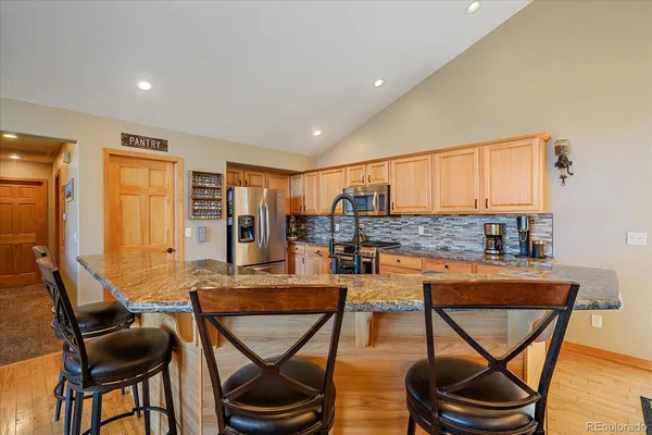 a living room with furniture a rug and kitchen view