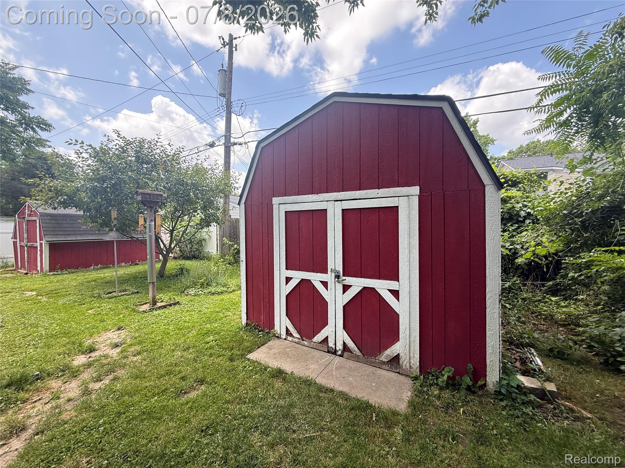 756 Cedarlawn Road Waterford, MI 48328 - Photo 29 of 34 Gable-style storage shed featuring red vertical siding, white trim, and double barn doors with metal hardware